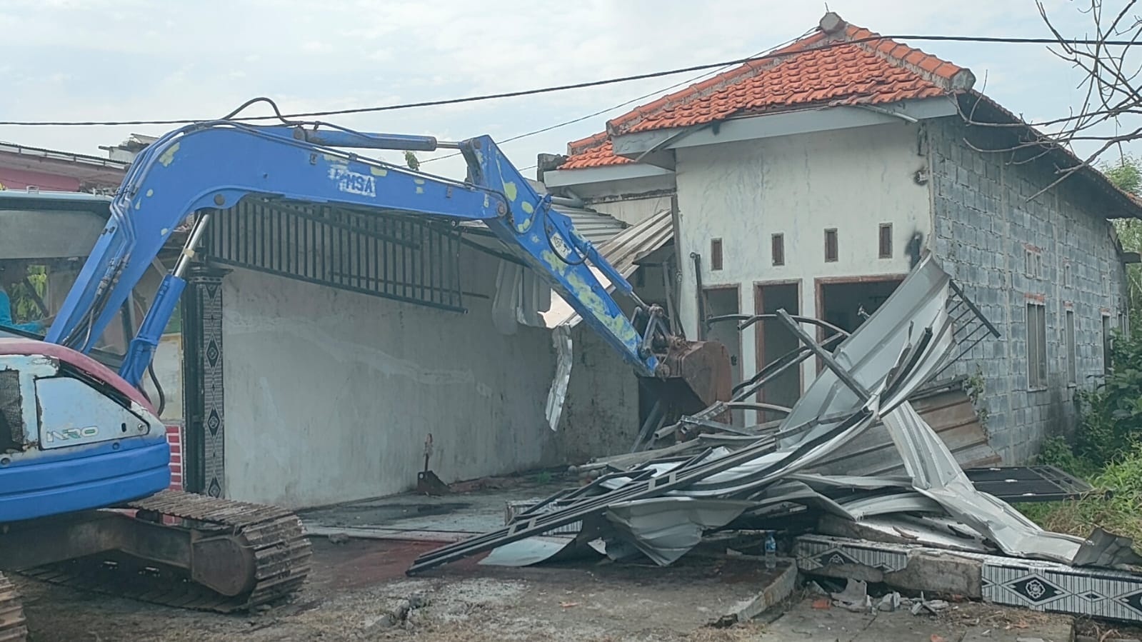 ROBOH: Menggunakan alat berat, juru sita PN Sidoarjo membongkar rumah di Desa Balongbendo, Kamis (12/2).
