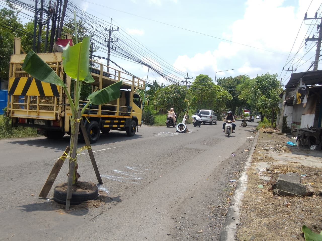 BERBAHAYA: Warga tanam pohon pisang di tengah Jalan Sadang-Kletek, Taman, Sidoarjo, Jumat (20/2). (DIKY SANSIRI/RADAR SIDOARJO)
