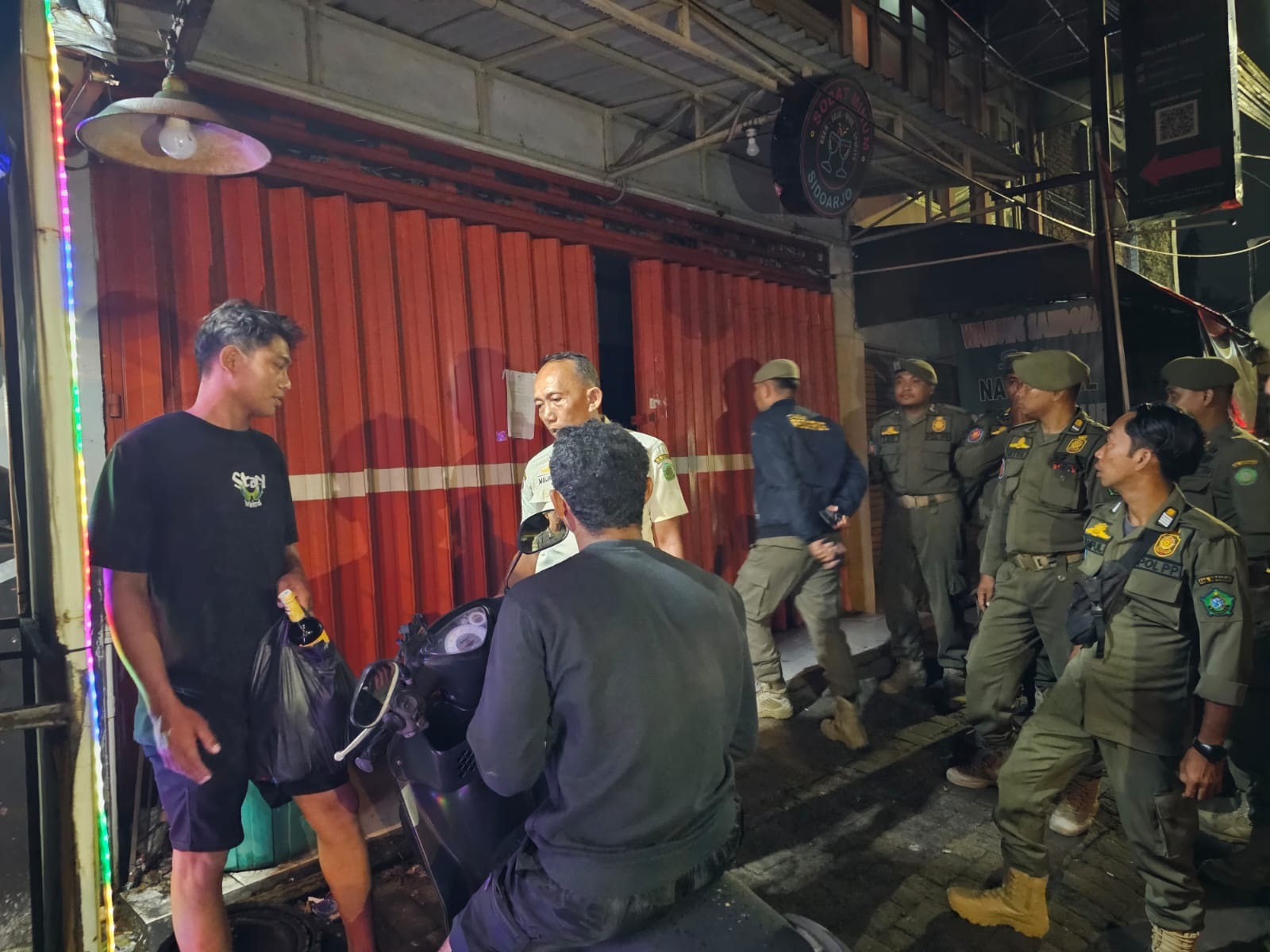 TEGAS: Petugas Satpol PP Sidoarjo menggerebek toko miras di Bungurasih, Waru.  