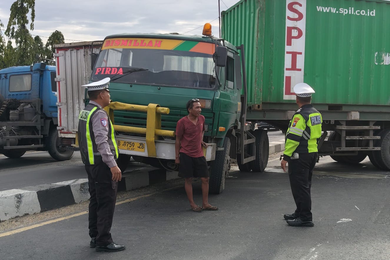 MACET: Petugas berusaha mengevakuasi truk yang bermasalah di flyover Trosobo, Taman.