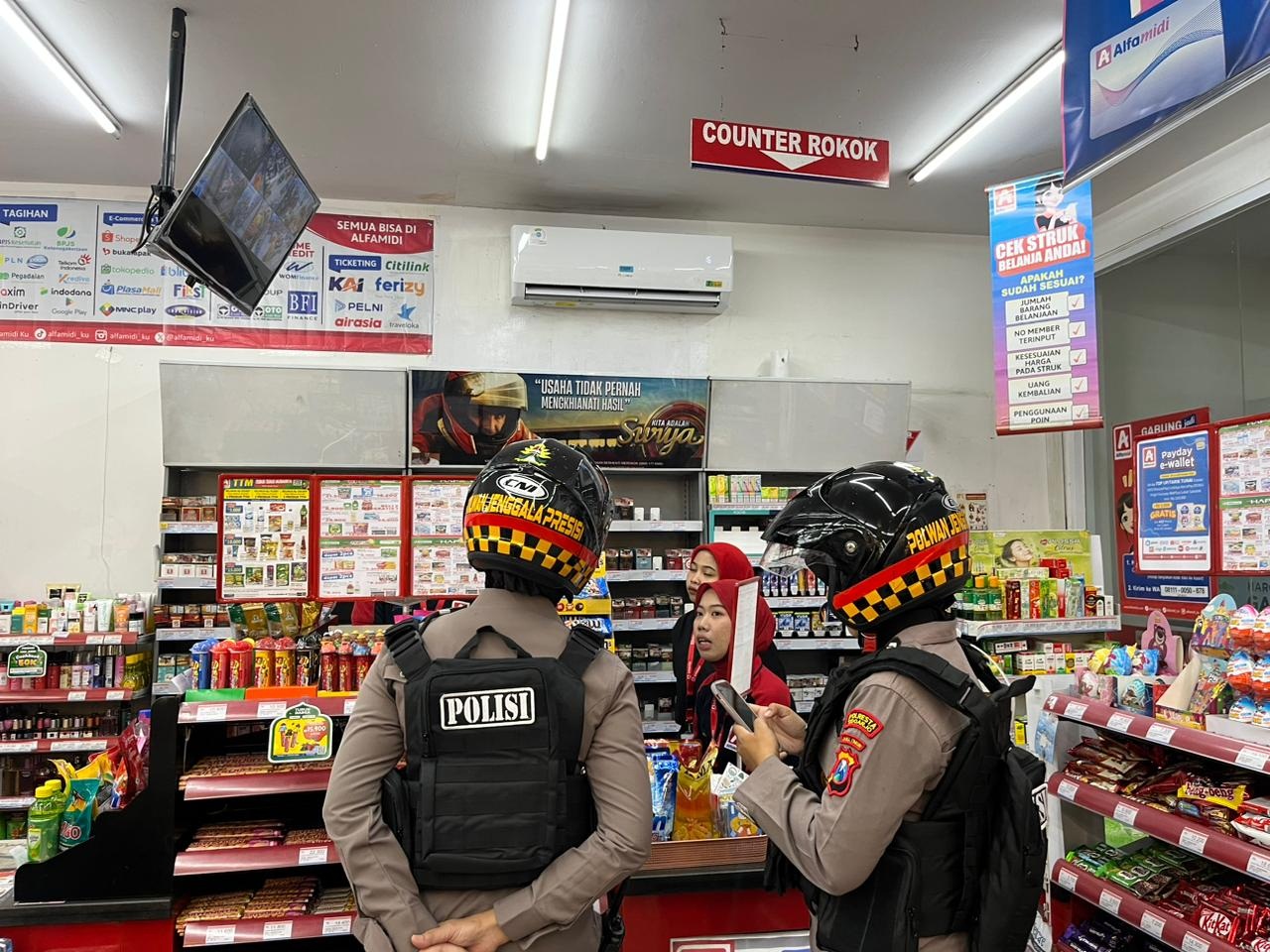 ANTISIPASI: Personel Polwan Polresta Sidoarjo berdialog dengan pegawai minimarket.