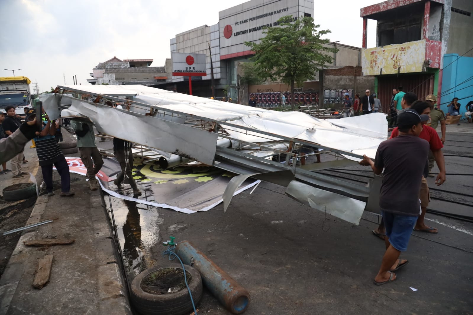 GOTONG ROYONG: Papan reklame menutupi akses jalan utama di Jalan Raya Gilang Taman, Jumat (7/3).
