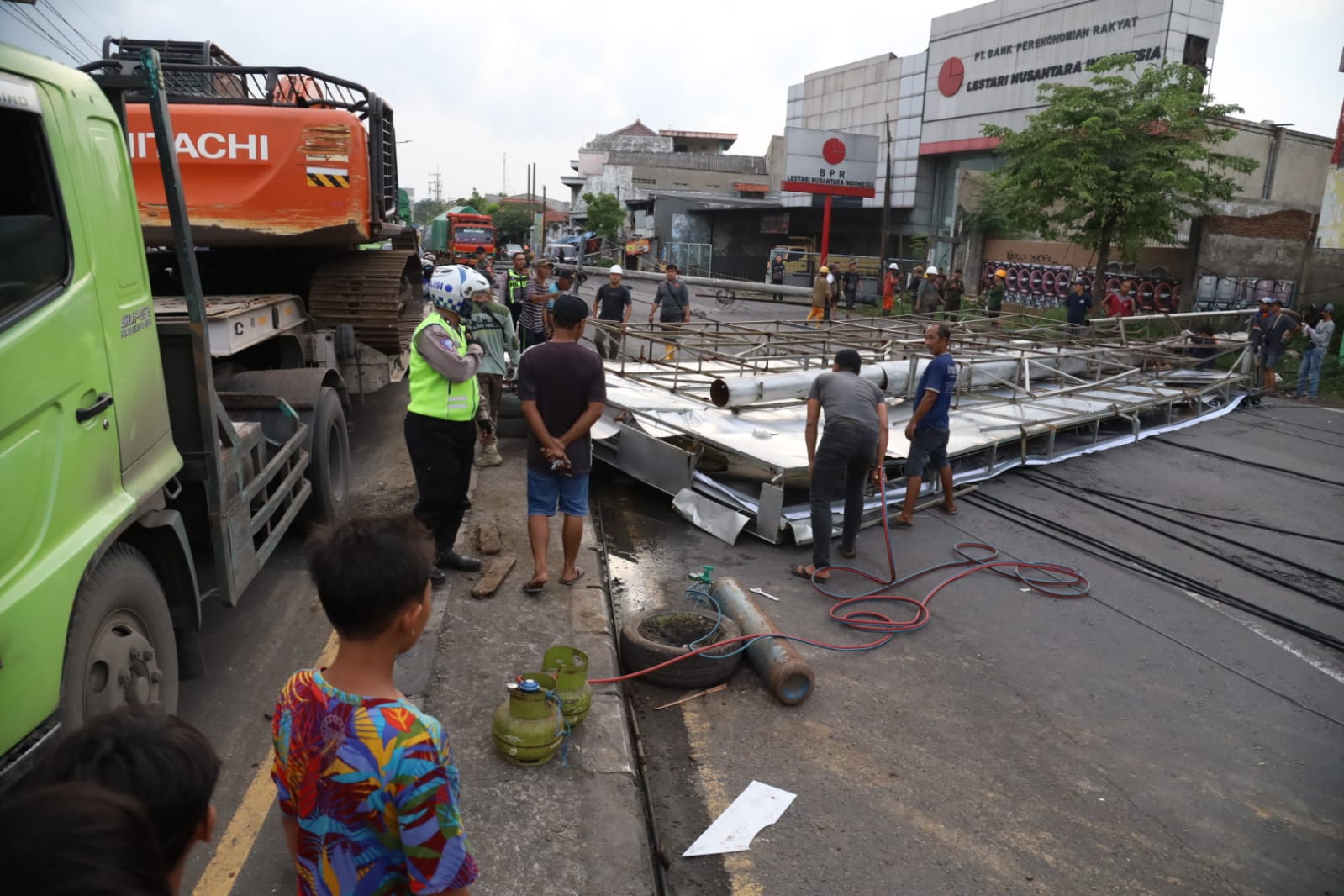 ALAT BERAT: Papan reklame menutupi akses jalan utama di Jalan Raya Gilang Taman, Jumat (7/3).