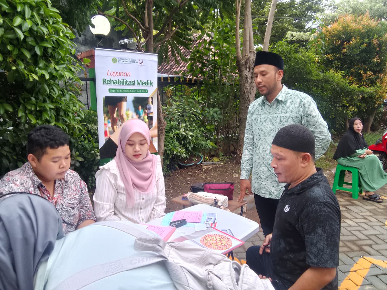 PELAYANAN: Direktur RSI Siti Hajar Sidoarjo dr Iqbal Faizin (berdiri) saat berkomunikasi dengan pemohon SIM keliling. (DIKY SANSIRI/RADAR SIDOARJO)
