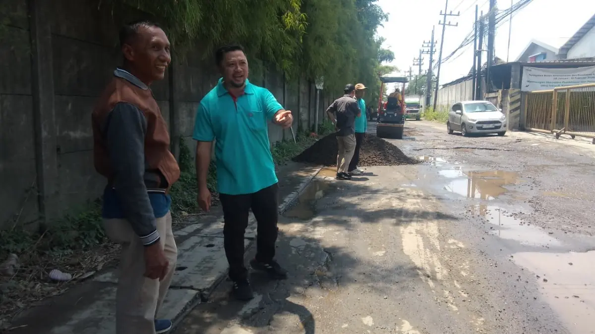 
BERLUBANG: Kepala Dinas PUBMSDA Kabupaten Sidoarjo, Muhammad Makhmud (kiri) dan Camat Gedangan Asmara Hadi saat mengecek perbaikan Jalan Muncul, Kecamatan Gedangan, Rabu (18/3). (DIKY SANSIRI/RADAR SIDOARJO)