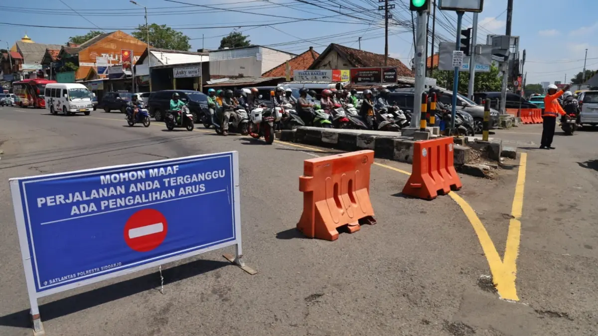 
PADAT: Petugas mengatur arus lalu lintas saat penerapan sistem satu arah (one way) di Jalan Letjen Sutoyo, Waru, Sidoarjo. (SURYANTO/RADAR SIDOARJO)