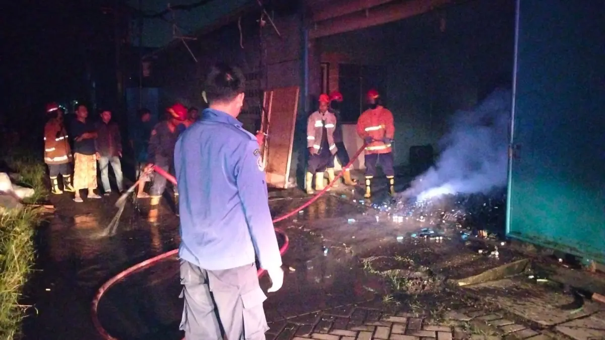 HANGUS: Petugas berusaha memadamkan api saat kebakaran melanda sebuah gudang di kawasan Trosobo.