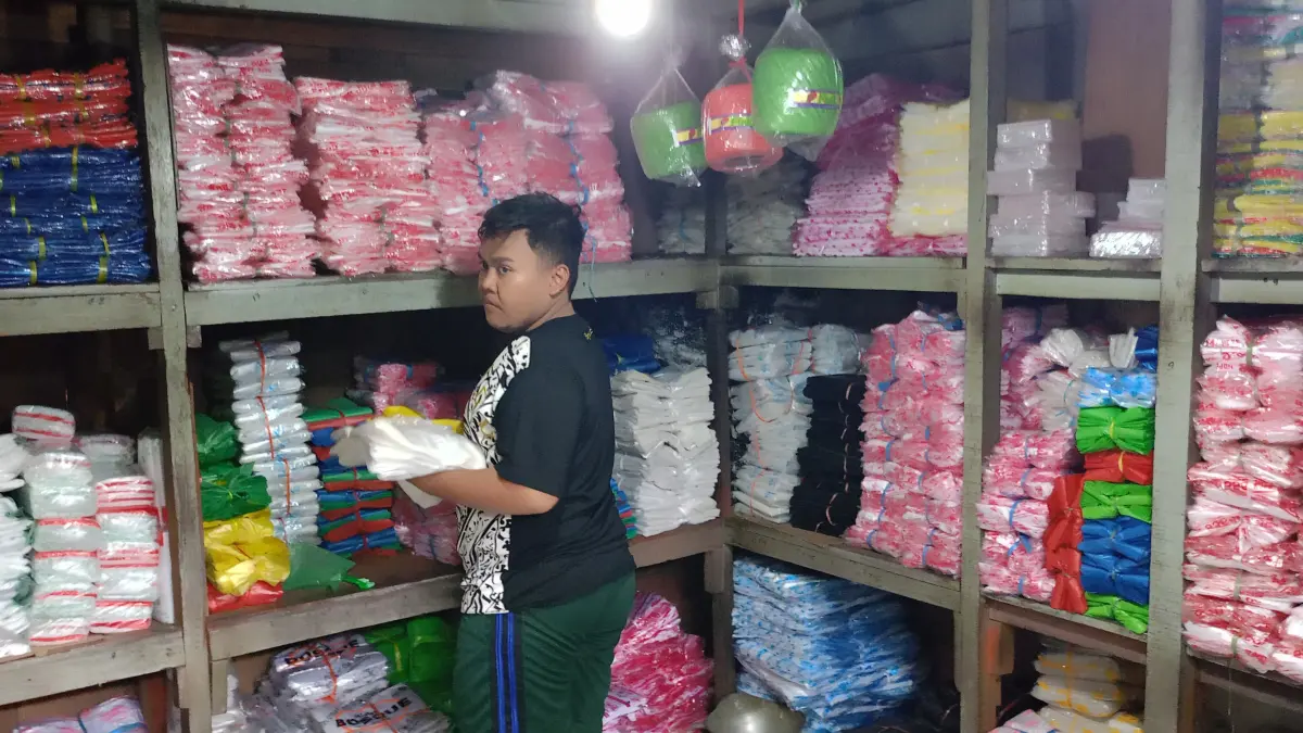 MEROKET: Pedagang plastik di Pasar Larangan Sidoarjo saat sedang melayani pembeli. (DIKY SANSIRI/RADAR SIDOARJO)