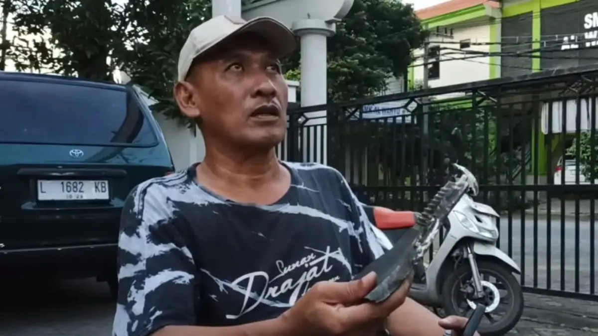 DAMPAK LEDAKAN: Warga menunjukkan lempengan besi yang ditemukan merusak rumahnya di Wedoro Regency, Waru. (SURYANTO/RADAR SIDOARJO)
