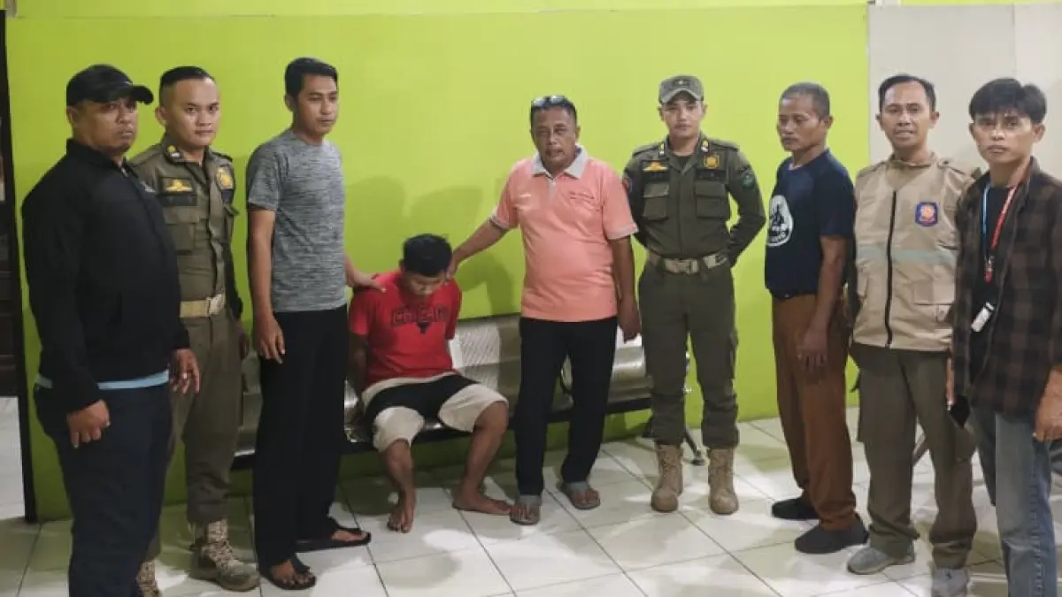 EVAKUASI: Personel Satpol PP Sidoarjo bersama warga usai mengamankan ODGJ (duduk) di Banjar Kemuning.&nbsp;