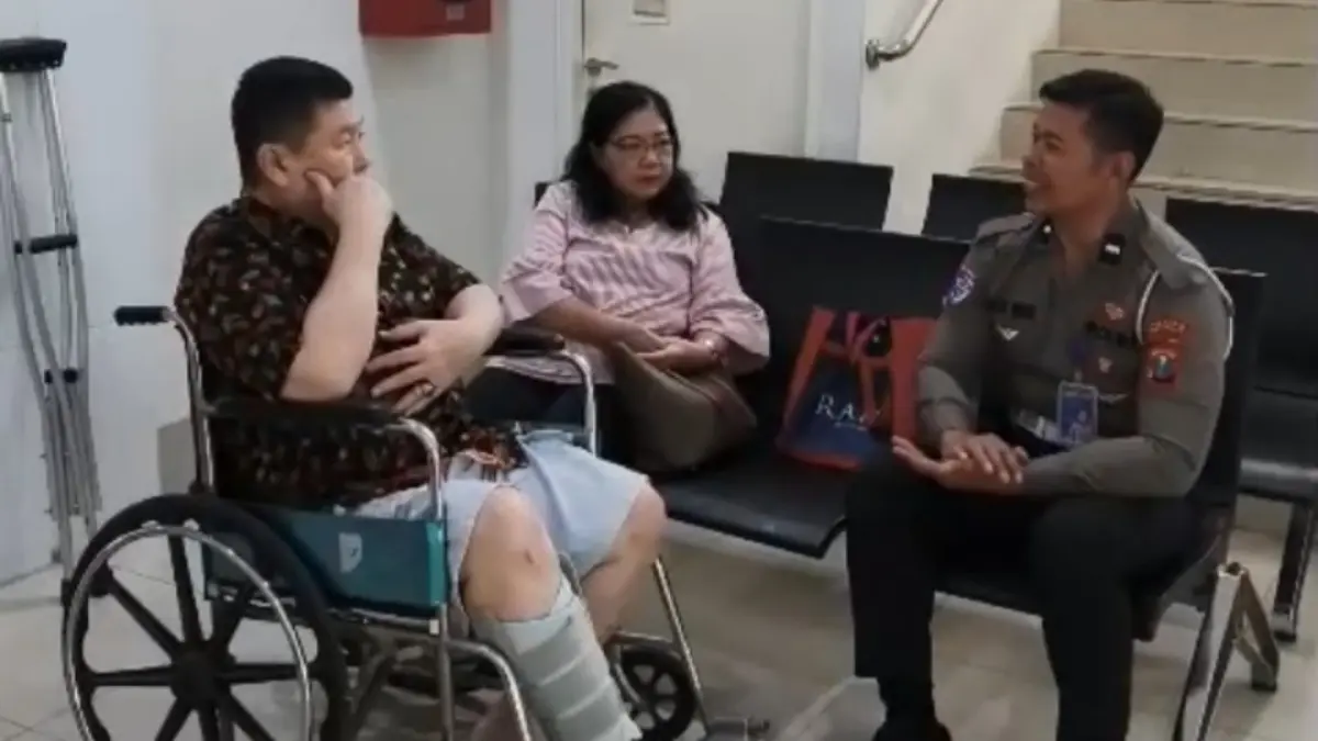 PEDULI: Personel Satlantas Polresta Sidoarjo membantu salah seorang pemohon SIM pengguna kursi roda di Satpas Polresta Sidoarjo.
