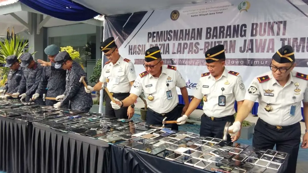 KETAT: Kepala Kanwil Ditjenpas Jatim, Kadiyono, memusnahkan handphone menggunakan palu, Selasa (21/4). (DIKY SANSIRI/RADAR SIDOARJO)