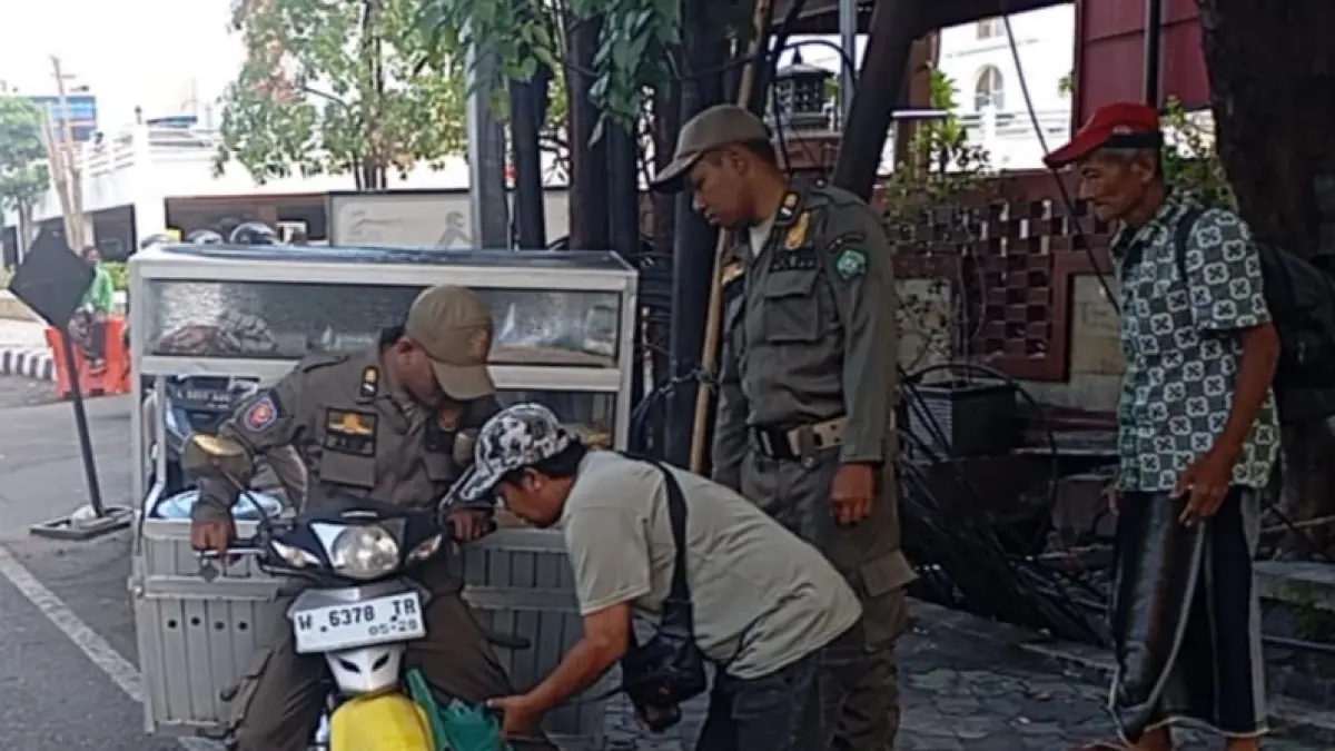 HUMANIS: Personel Satpol PP Sidoarjo saat menertibkan PKL di salah satu jalan protokol Sidoarjo.