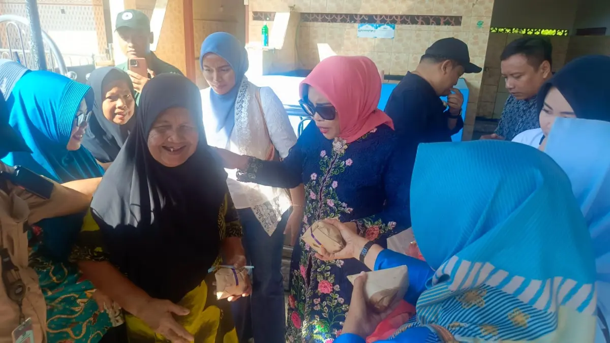 NAIK PERAHU: Wabup Mimik membagikan nasi bungkus kepada warga serta kue kepada anak-anak SD.