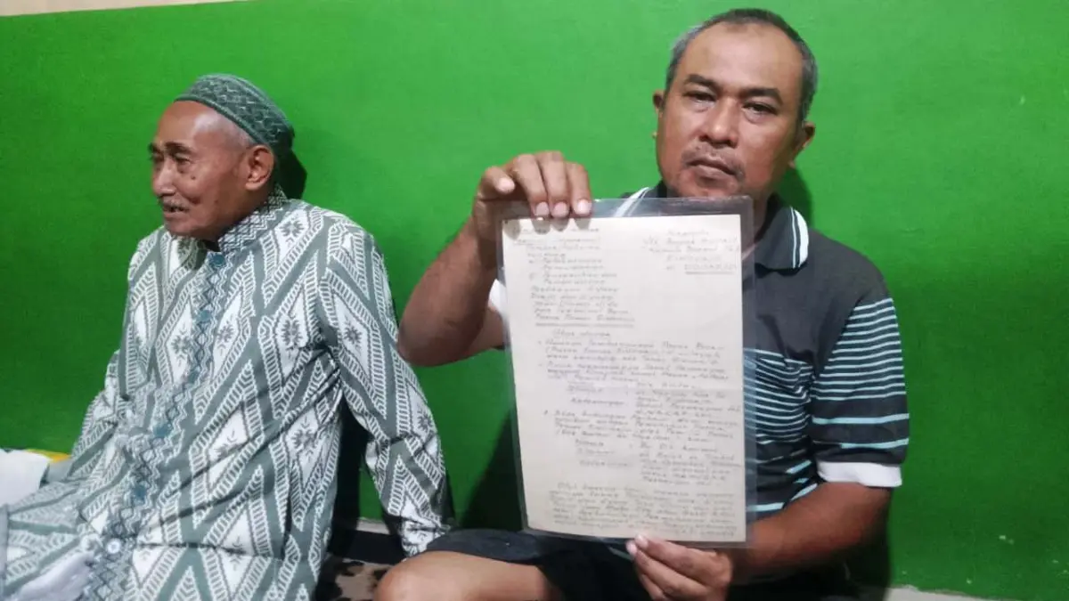 BUKTI: Ahli waris Saifudin (kanan) menunjukkan surat keterangan waris didampingi pamannya, Moh Dahlan. (DIKY SANSIRI/RADAR SIDOARJO)