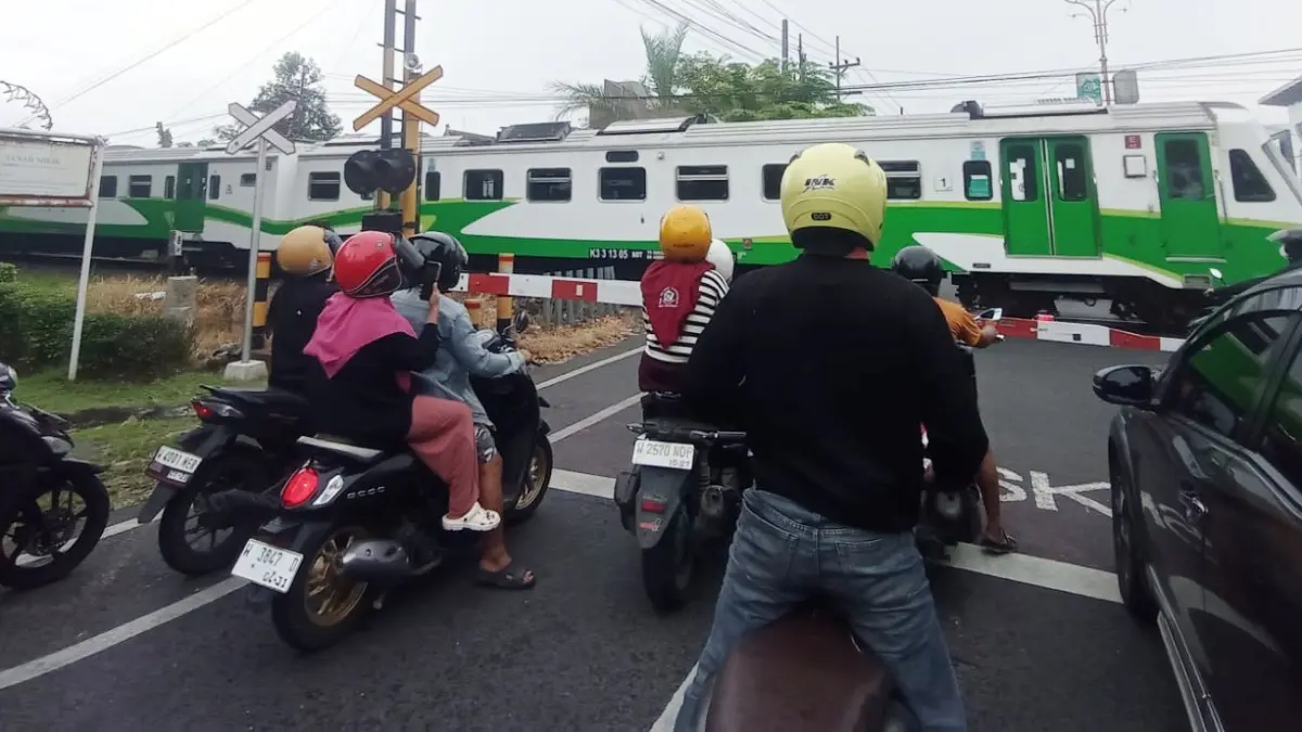 BIAR AMAN: Pengendara kendaraan bermotor menunggu kereta api melintas di Sidoarjo. (SURYANTO/RADAR SIDOARJO)