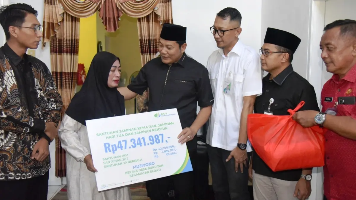 PEDULI: Bupati Sidoarjo Subandi menyerahkan santunan kepada istri Kepala Desa Buncitan saat takziah, Jumat (8/5).