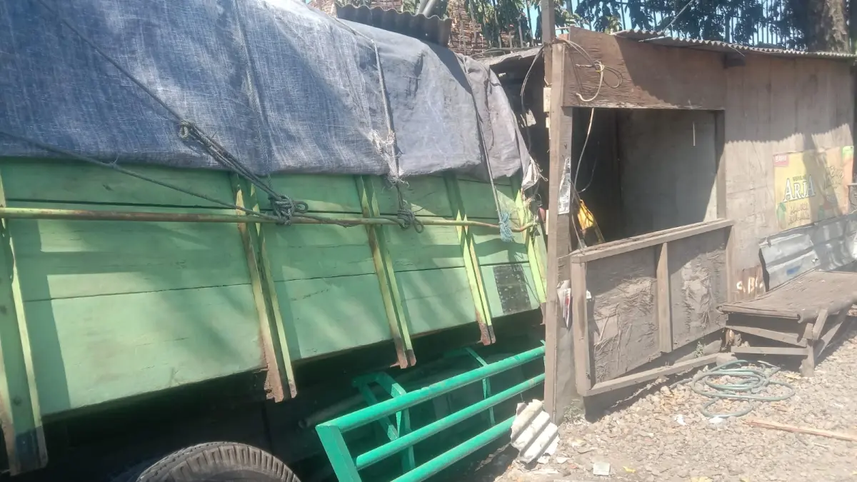 RUSAK: Truk mengalami kecelakaan tunggal hingga menabrak warung tambal ban dan tembok pabrik.