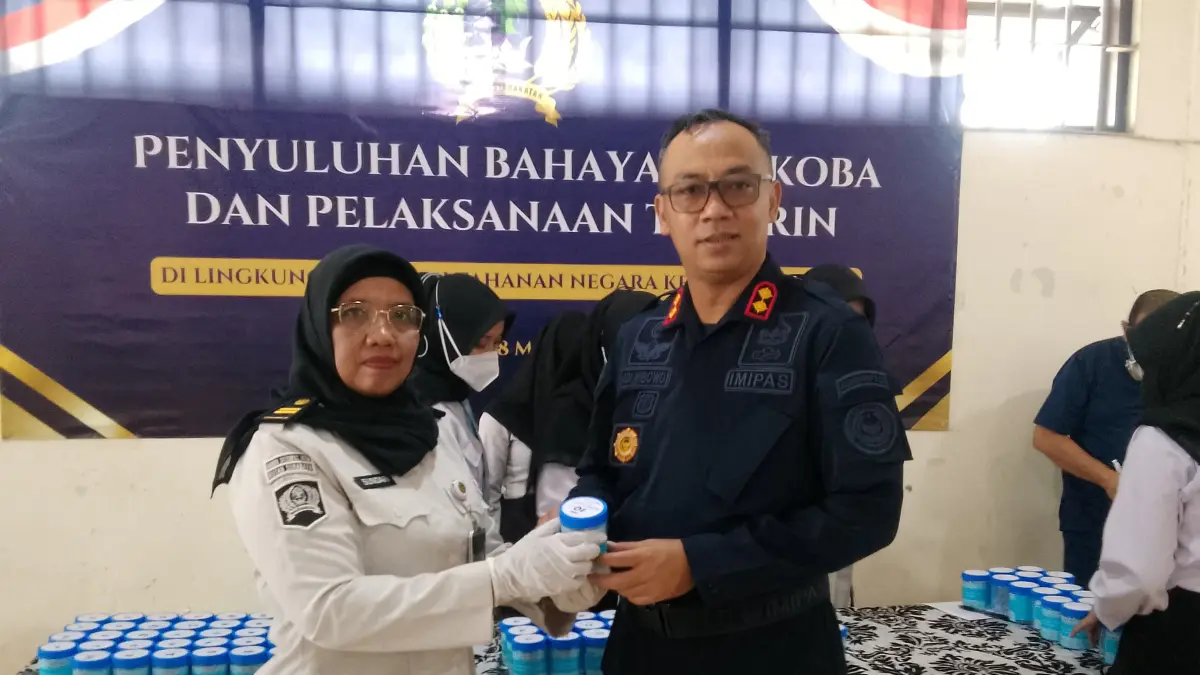 BERANTAS: Karutan Kelas I Surabaya Tristiantoro Adi Wibowo (kanan) bersama petugas tunjukkan urine warga binaan.