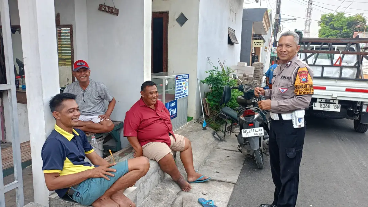 KOMUNIKASI: Bhabinkamtibmas Buduran saat berdialog dengan warga jelang pelaksanaan Pilkades di Desa Sidokerto, Buduran.