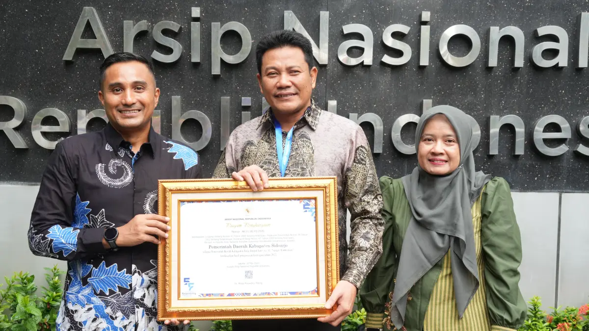 APRESIASI: Bupati Sidoarjo Subandi (tengah) dan Kepala Dinas Perpustakaan dan Kearsipan (Kadisperpusip) Sidoarjo Rudi Setiawan (kiri) menunjukkan penghargaan yang diterima.
