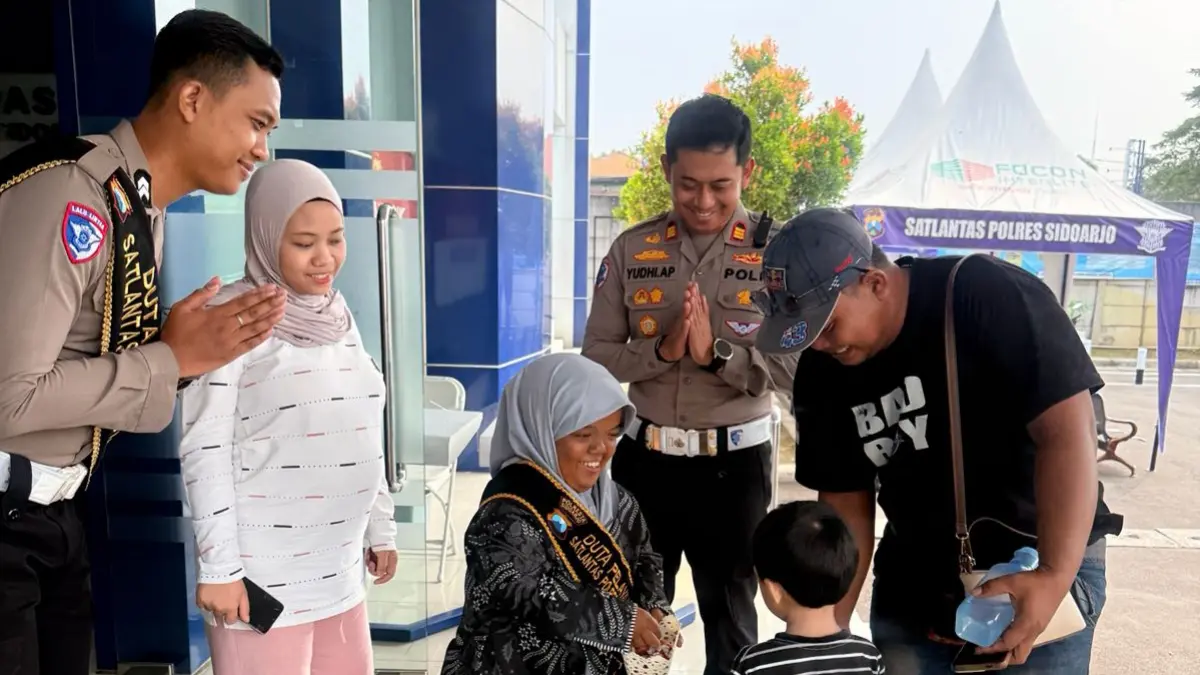 INKLUSIF: Prita didampingi Kasat Lantas Polresta Sidoarjo AKP Yudhi Anugrah Putra (tengah) saat menjalankan tugasnya sebagai Duta Pelayanan di Satpas Polresta Sidoarjo.&nbsp;