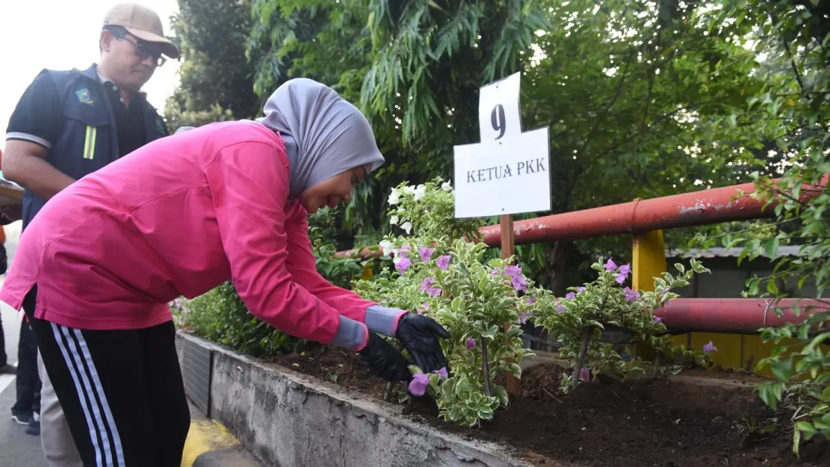 INDAH: Ketua TP PKK Kabupaten Sidoarjo Sriatun Subandi saat menanam bunga bugenvil di kawasan Flyover Jenggolo.