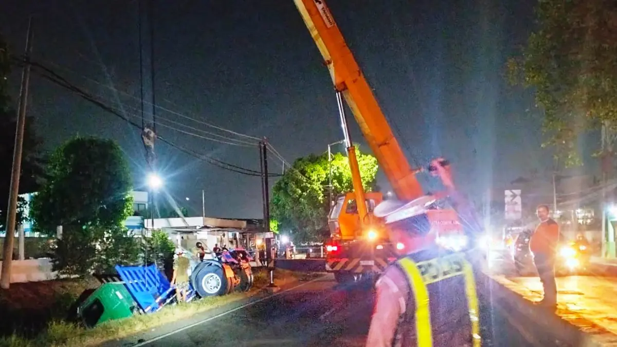 MACET: Proses evakuasi truk kontainer yang terperosok ke parit di Jalan Raya Sidorejo, Kecamatan Krian.