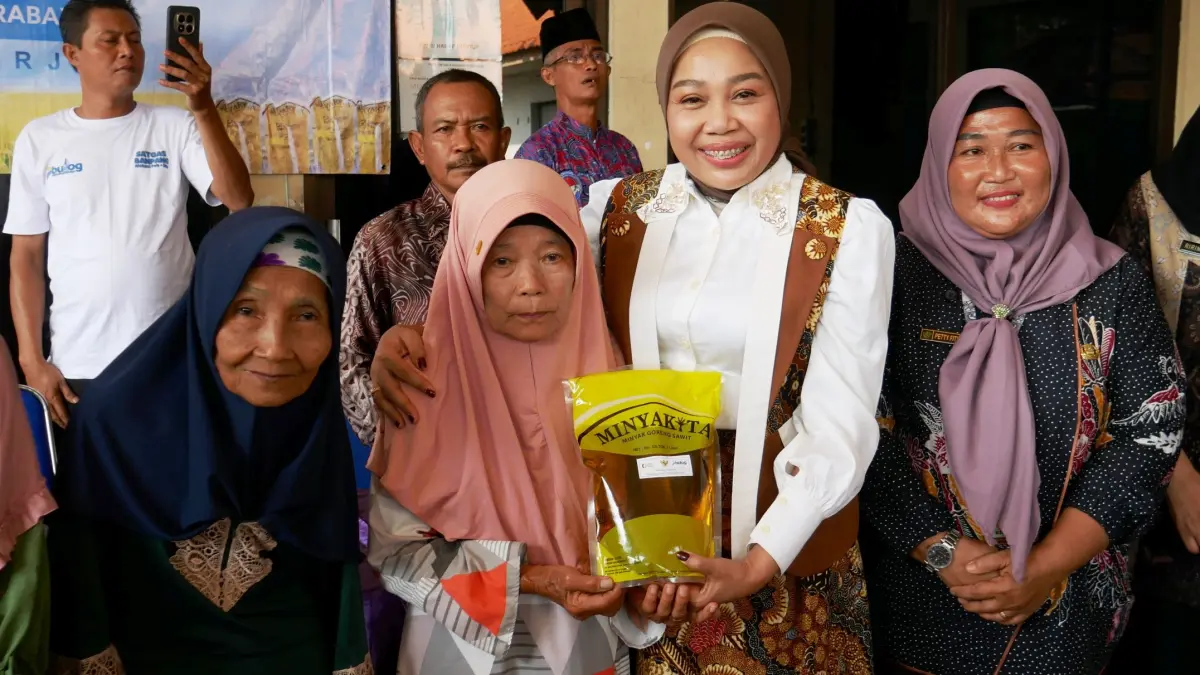 MERANGKUL: Ketua TP PKK Kabupaten Sidoarjo Sriatun Subandi menyalurkan bantuan pangan berupa beras dan minyak goreng kepada 2.052 keluarga penerima manfaat (KPM) di empat desa, Kamis (18/6).