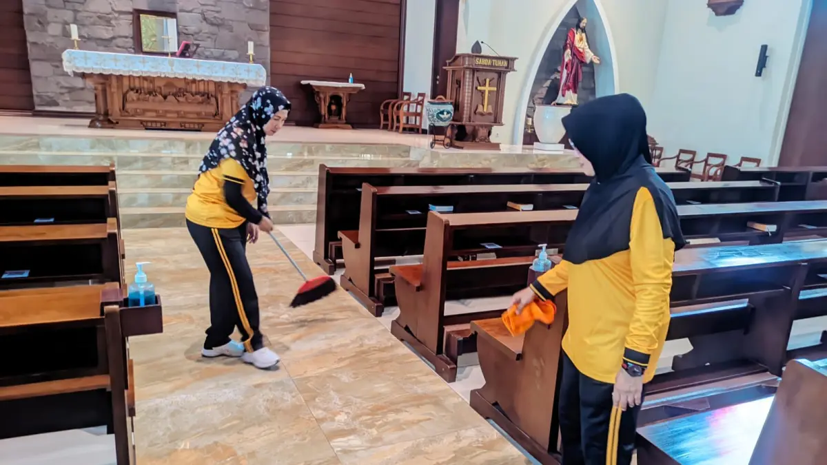 TOLERANSI: Personel kepolisian Polsek Krian bersih-bersih rumah ibadah dalam rangka hari Bhayangkara.&nbsp;