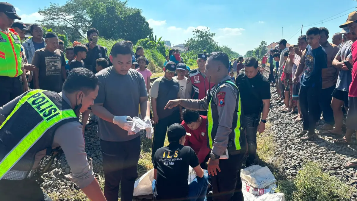 TRAGIS: Petugas mengevakuasi korban kecelakaan kereta api di Keboharan, Krian, Sidoarjo.&nbsp;