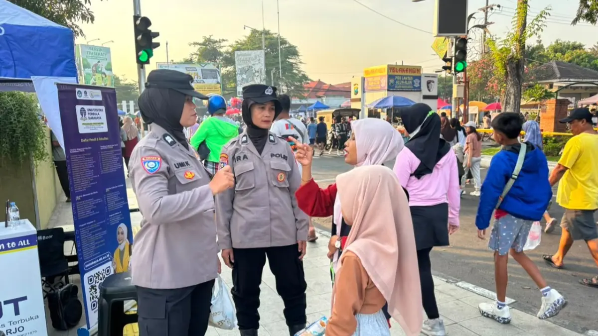 AMAN: Personel Polwan Polresta Sidoarjo menyapaa warga saat Car Free Day di kawasan Alun-alun Sidoarjo.&nbsp;