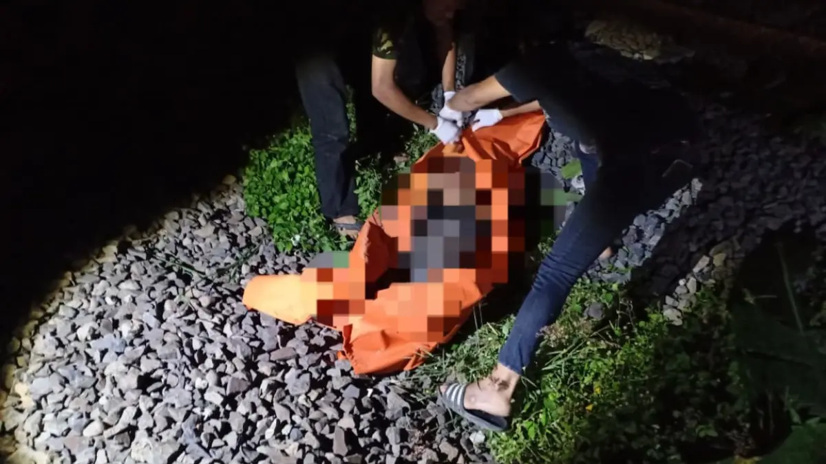 TRAGIS: Petugas mengevakuasi jenazah korban yang tersambar kereta api di Kramat Jegu, Taman, Sidoarjo.&nbsp;