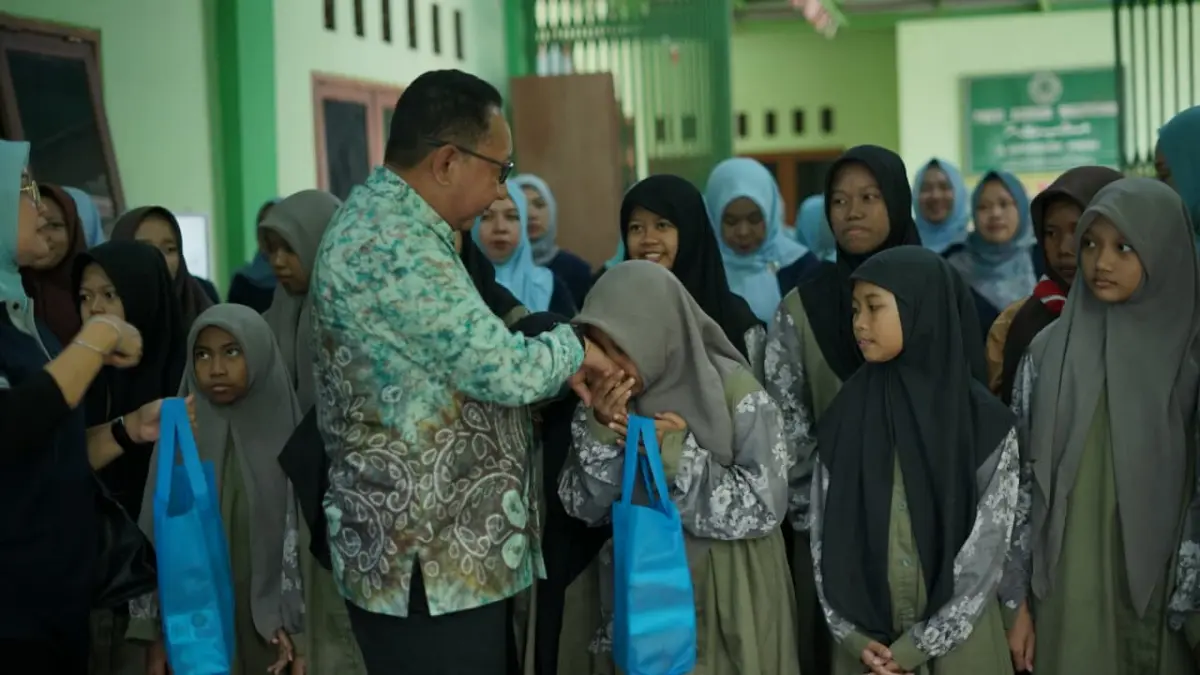 PEDULI: Kepala Lapas Kelas I Surabaya Sohibur Rachman menyerahkan bantuan sembako dan bingkisan kepada anak-anak Panti Asuhan Masyithoh, Porong, dalam rangka Hari Anak Nasional 2026.