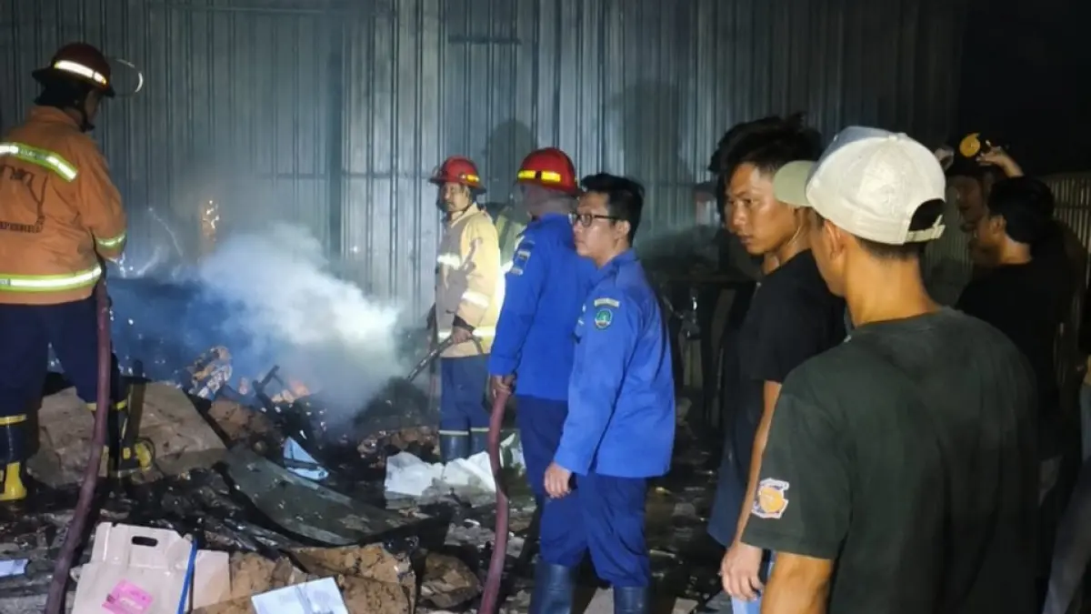 PEMADAMAN: Petugas melakukan pembasahan saat kebakaran melanda sebuah gudang karton di Sidomulyo, Krian.&nbsp;