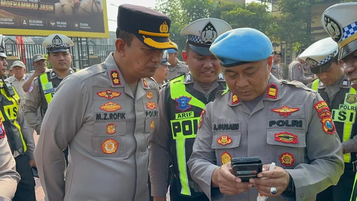 ANTISIPASI: Wakapolresta Sidoarjo AKBP Mohammad Zainur Rofiq (kiri) saat memeriksa ponsel personel Polri dan ASN usai apel pagi.&nbsp;
