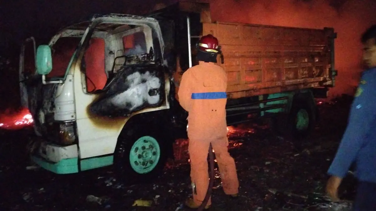 
HANGUS: Petugas pemadam kebakaran memadamkan api yang membakar sebuah truk sampah.