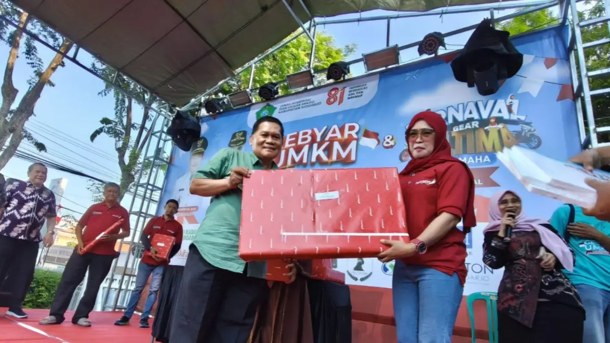 PEMENANG: Kepala Dinkop UM Sidoarjo, Mochammad Hudori menyerahkan hadiah pada perwakilan Nine Art Gallery usai merupakan omset terbanyak.(ANDY SATRIA/RADAR SIDOARJO)