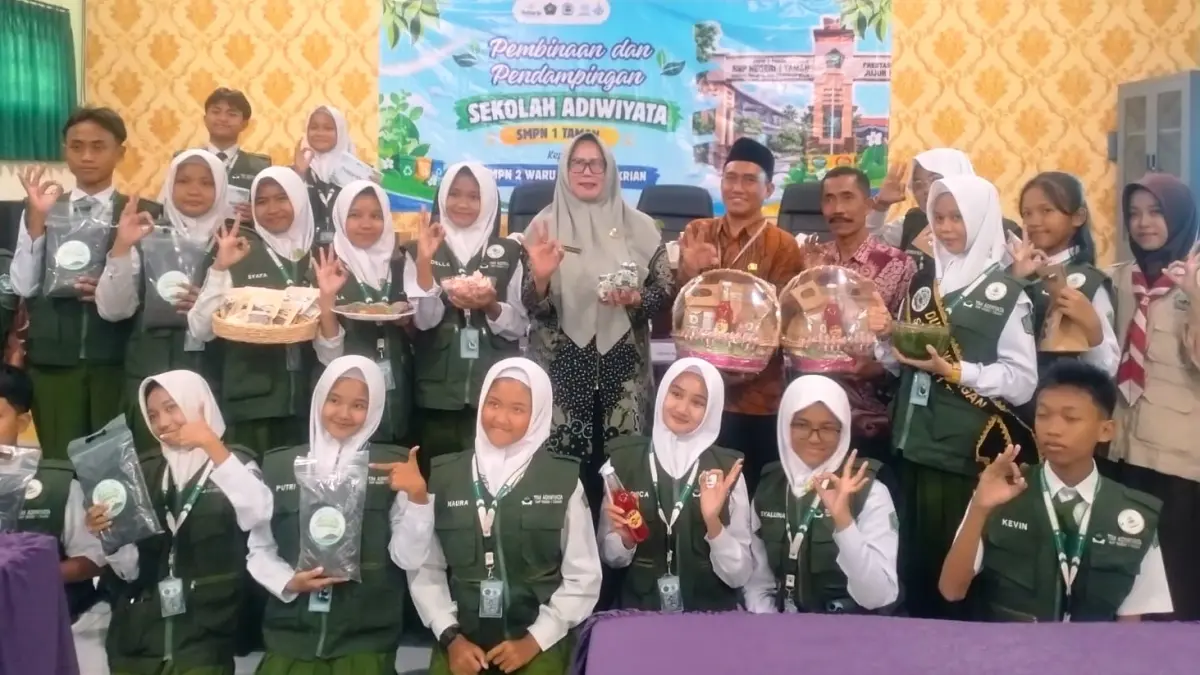 KREATIF: Kepala SMPN 1 Taman, Dra. Masroh Hidajati, M.Pd., bersama dewan guru dan kader Adiwiyata SMPN 1 Taman menunjukkan produk unggulan hasil karya sekolah dalam kegiatan bersama kader Adiwiyata dari SMPN 1 Taman, SMPN 3 Krian, dan SMPN 2 Waru. (ANAS/RADAR SIDOARJO)