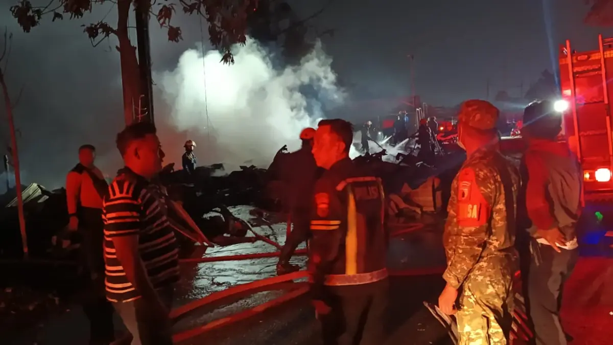 MEMBARA: Petugas berusaha memadamkan api saat kebakaran di Krian, Sidoarjo.