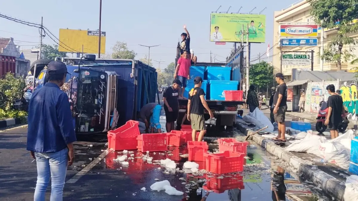 APES: Petugas dan warga berusaha mengevakuasi truk yang terguling di Bypass Juanda, Sedati, Sidoarjo.