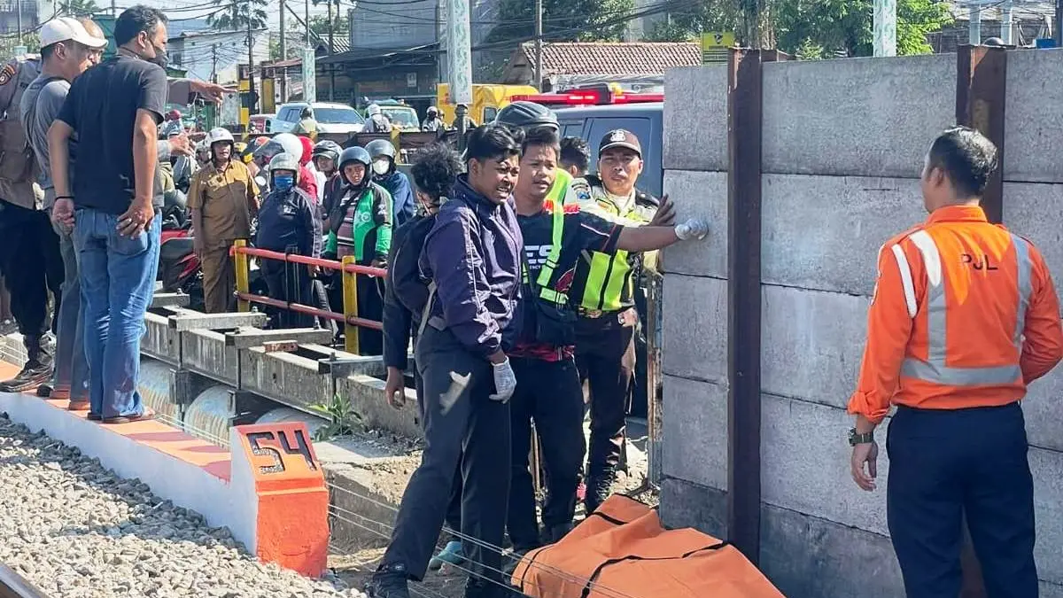 DIEVAKUASI: Petugas dan warga mengevakuasi jenazah S yang tertabrak kereta api di kawasan Jalan Kolonel Sugiono, Waru, Sidoarjo.