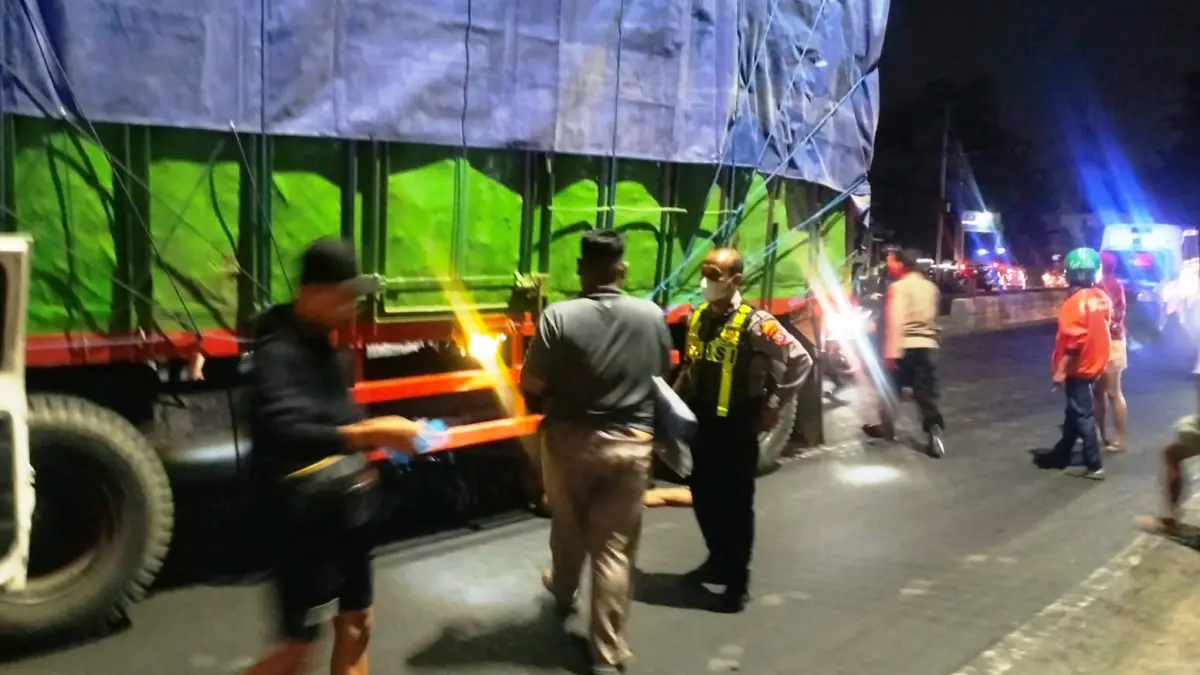 TRAGIS: Polisi dibantu warga saat akan mengevakuasi korban kecelakaan.