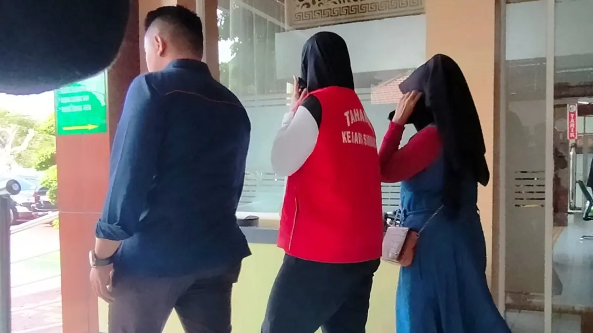 PESAKITAN: Terdakwa Reza Kustuyanti (tengah) usai menjalani sidang di Pengadilan Negeri Sidoarjo.