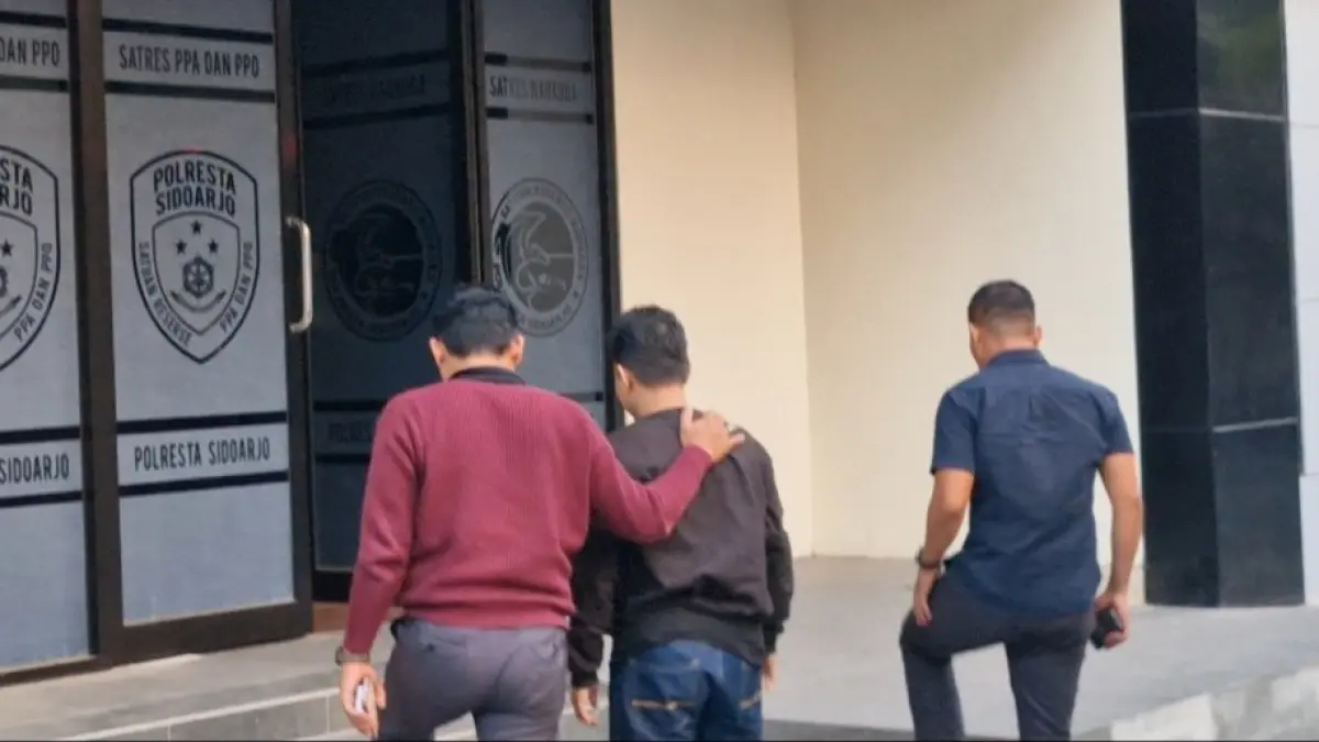 BEJAT: Terduga pelaku (tengah) saat diamankan di Mapolresta Sidoarjo.