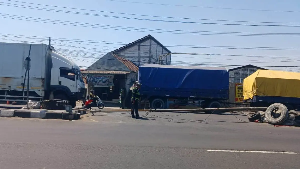 TABRAK LARI: Petugas mengatur arus lalu lintas saat tiang PJU roboh di Taman, Sidoarjo.