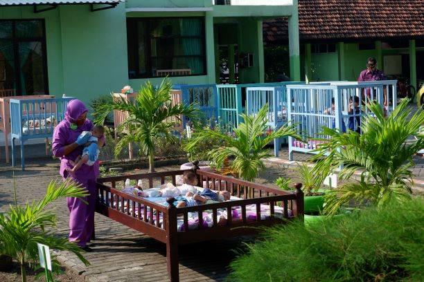 BIAR SEHAT: Berjemur di pagi hari jadi kegiatan rutin bayi dan balita yang dirawat UPT Perlindungan dan Pelayanan Sosial Asuhan Balita (PPSAB) Dinas Sosial Jawa Timur di Jalan Mongonsidi.  (RIZKY PUTRI PRATIMI/RADAR SIDOARJO)