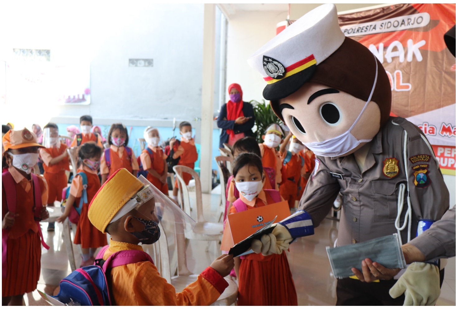 EDUKASI: Badut polisi saat memberikan edukasi penggunaan masker kepada anak-anak. (LUKMAN AL FARISI/RADAR SIDOARJO)