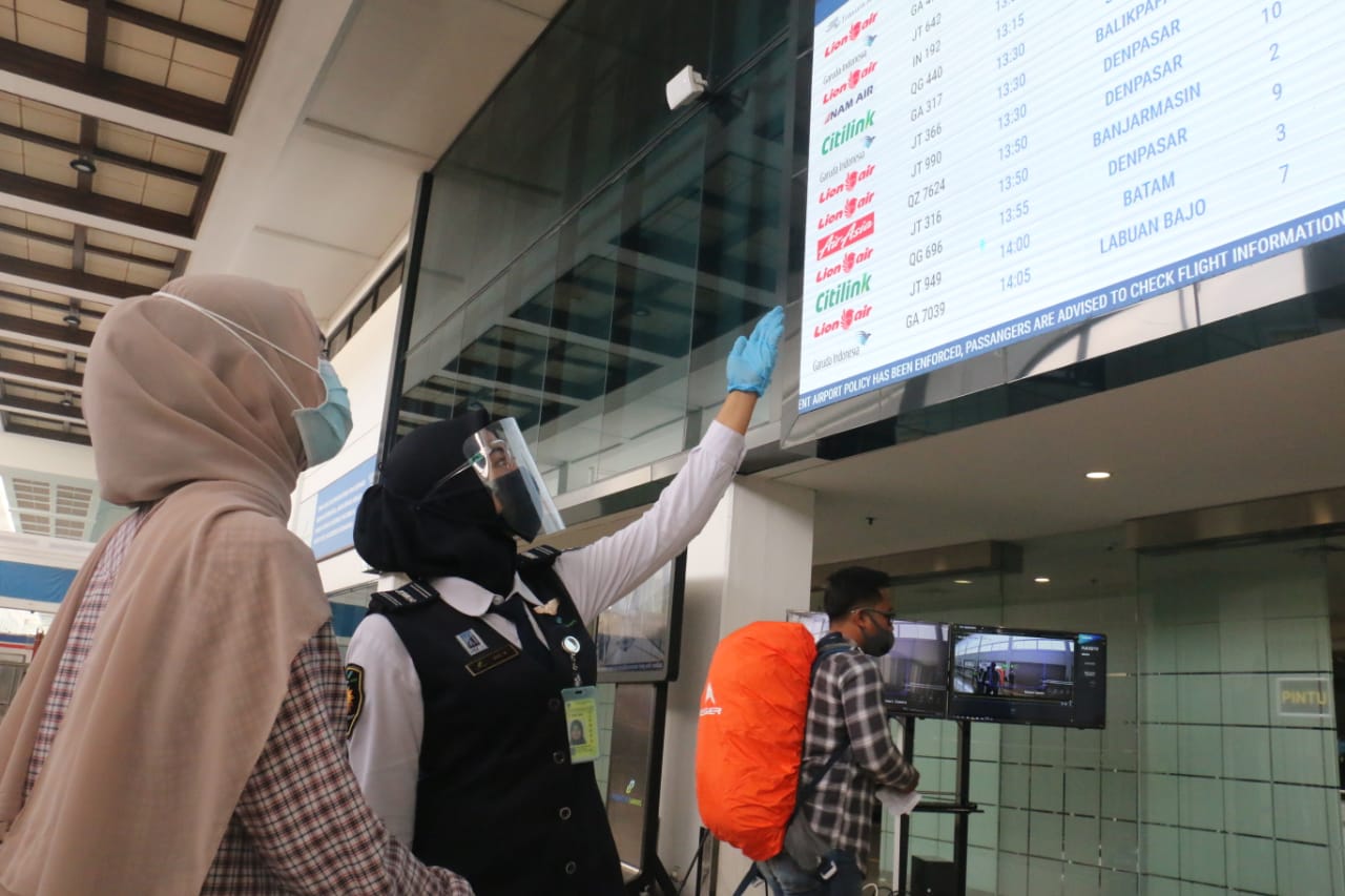 CERMAT: Petugas Bandara Internasional Juanda menjelaskan jadwal aktivitas pesawat pada salah satu calon penumpang. (IST)