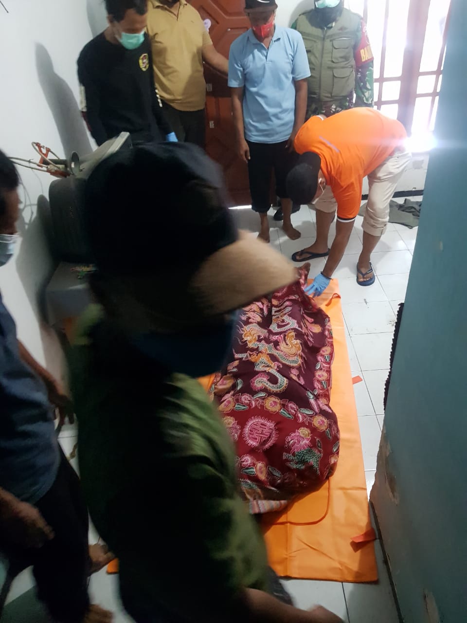 DIEVAKUASI: Korban saat dievakuasi oleh pihak kepolisian usai ditemukan tewas menggantung di dalam rumah. (IST)